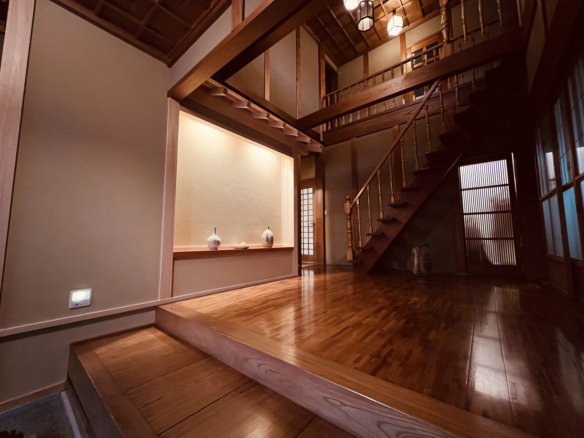 高級旅館のような玄関リフォーム。間接照明でライトアップされた造作飾り床としつらえ。和の趣あふれる玄関インテリア。